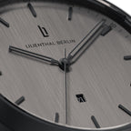 Close-up of minimalist silver watch face with date display and sleek black hour markers