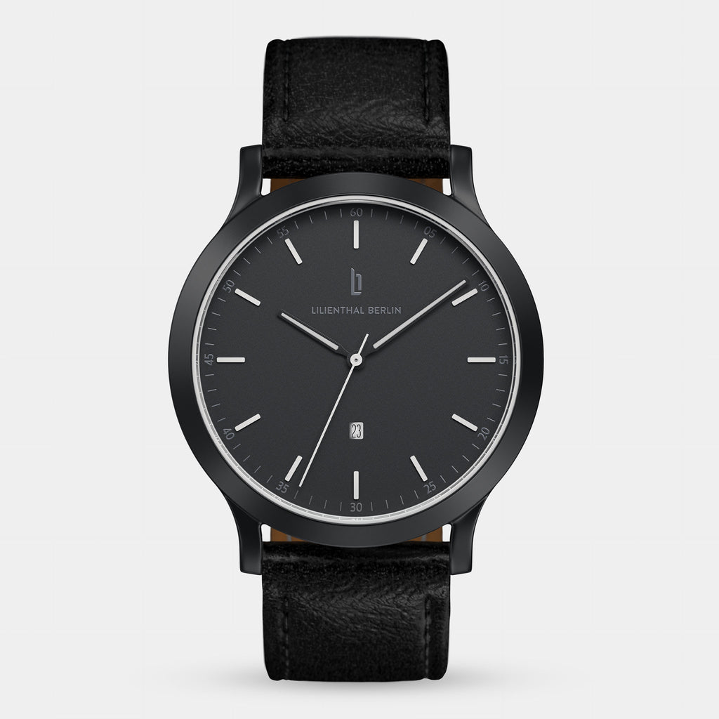 Minimalist black wristwatch with leather strap and date window, modern dial design