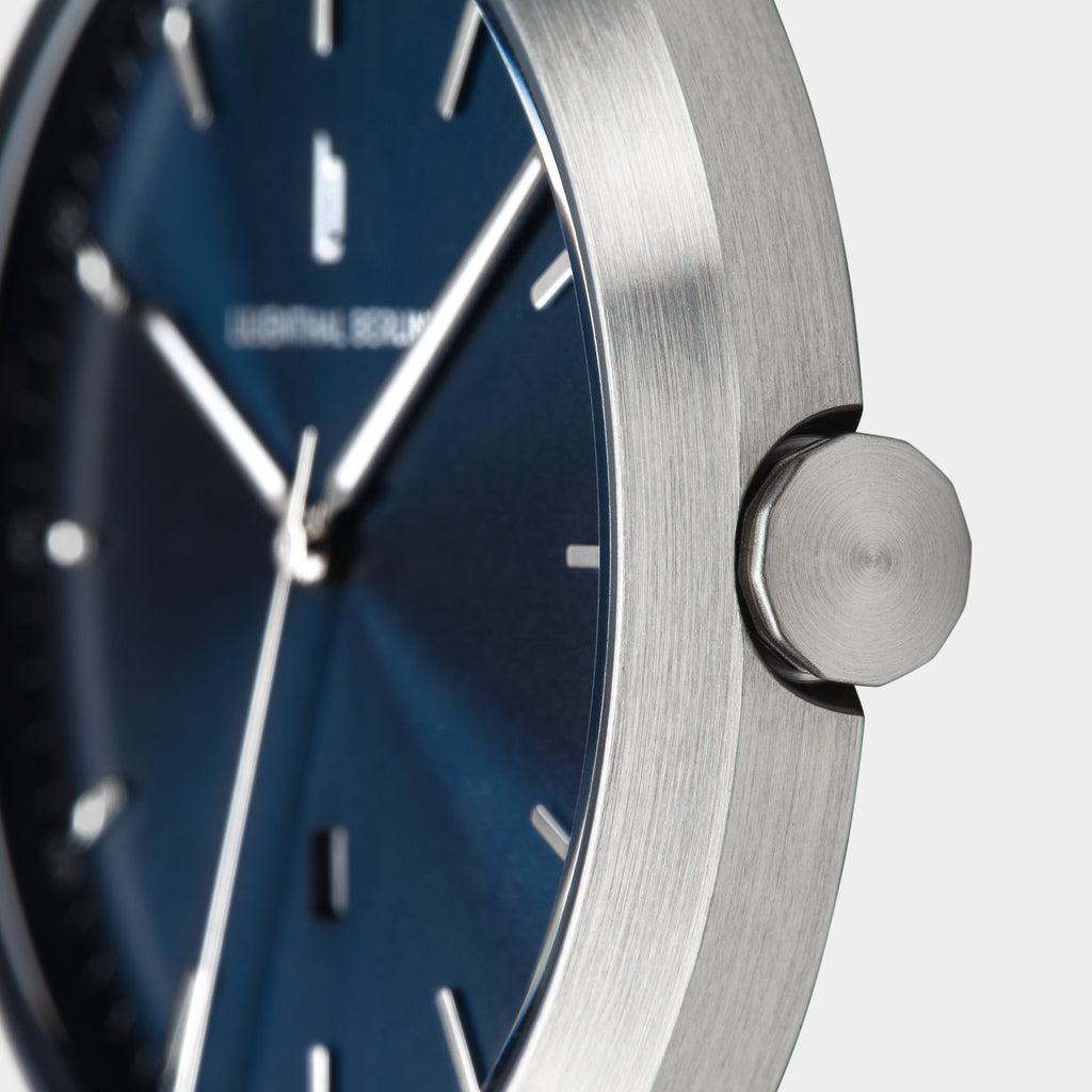 Close-up of minimalist silver watch with blue dial and silver hour markers