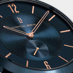 Close-up of a modern blue watch face with rose gold hands and hour markers